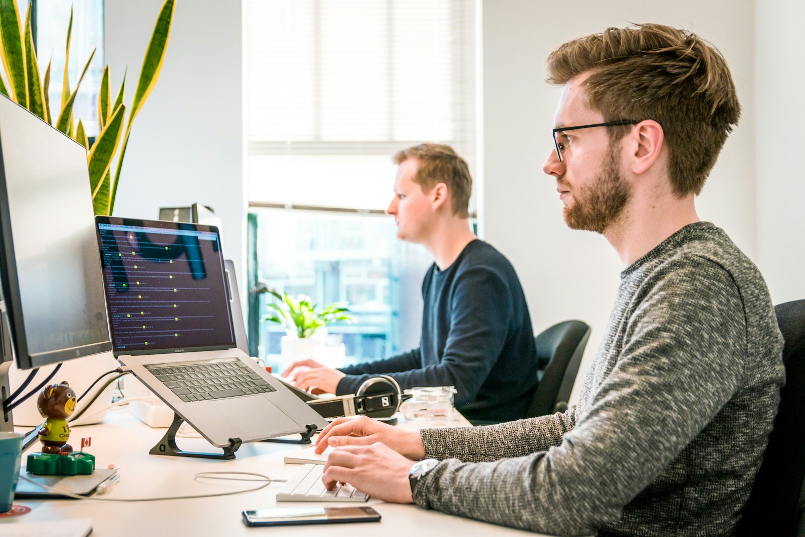 Two developers working at their desks in a bright office