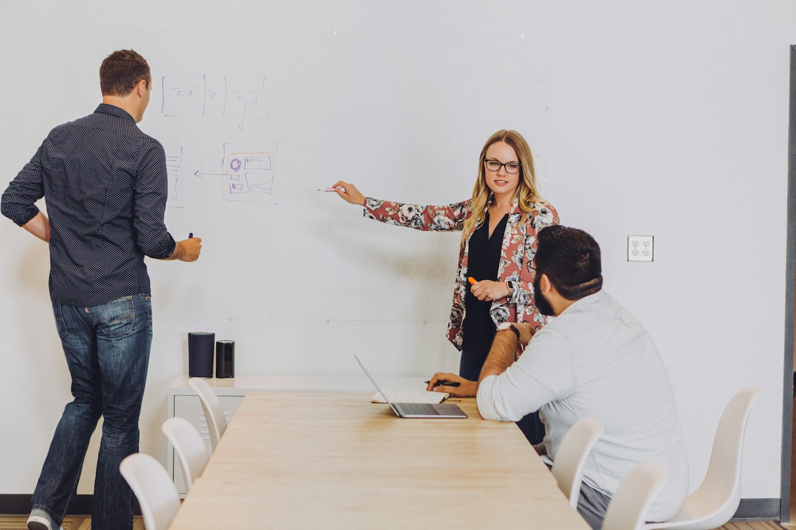Colleagues discussing ideas at a whiteboard